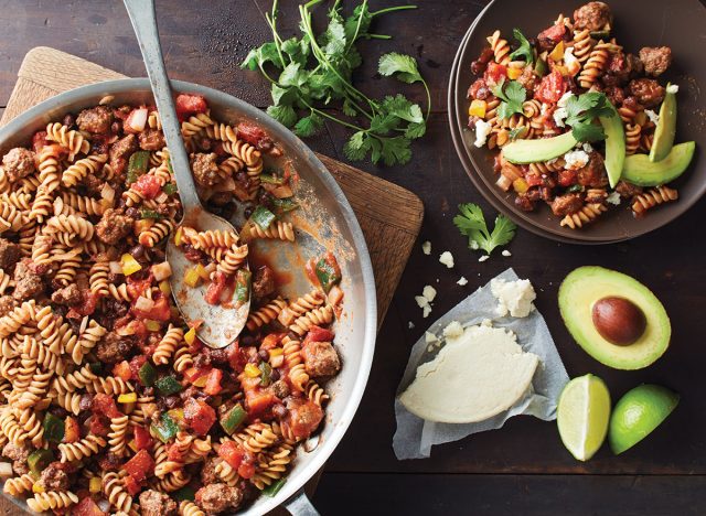 une poêle à tacos avec une cuillère, du fromage cotija et des tranches d'avocat