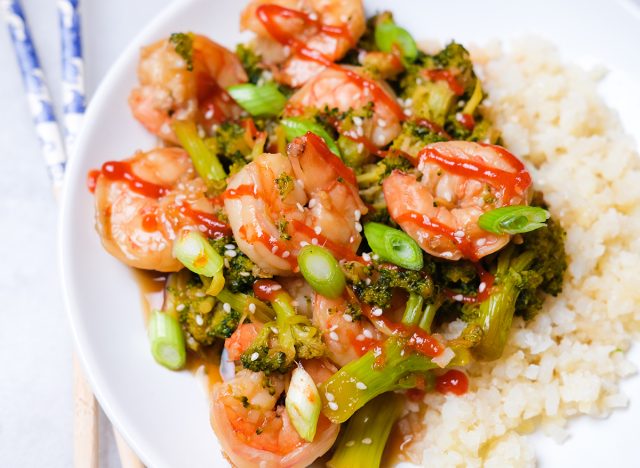 crevettes et brocolis avec riz de chou-fleur saupoudré de graines de sésame oignons verts et sriracha
